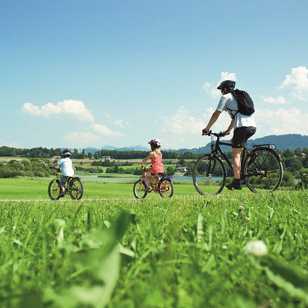 Radtour bei Memmingen im Allgäu mit Blick auf grüne Felder und die sanften Hügel des Allgäus.